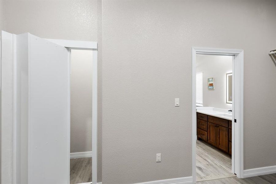 Bathroom featuring light wood-type flooring, vanity, and a textured wall