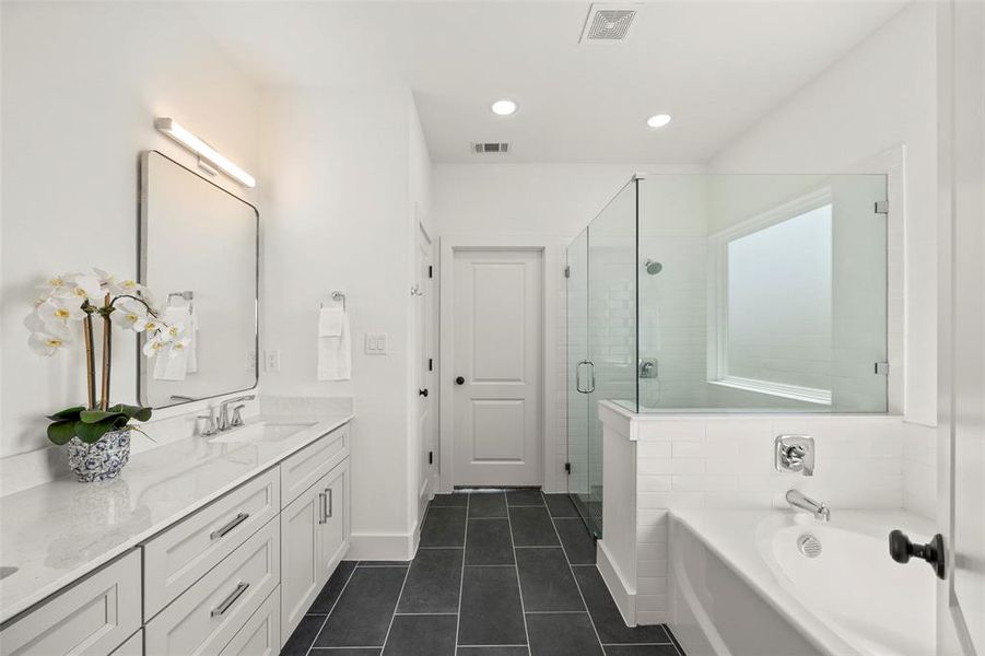 Bathroom with tile flooring, separate shower and tub, and vanity with extensive cabinet space