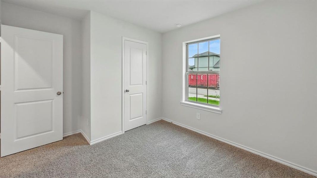 Unfurnished bedroom with baseboards and light colored carpet