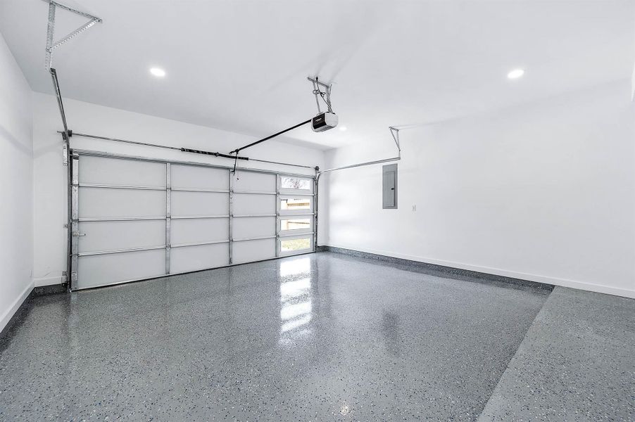 Spacious two-car garage featuring epoxy flooring and a clean, finished interior.