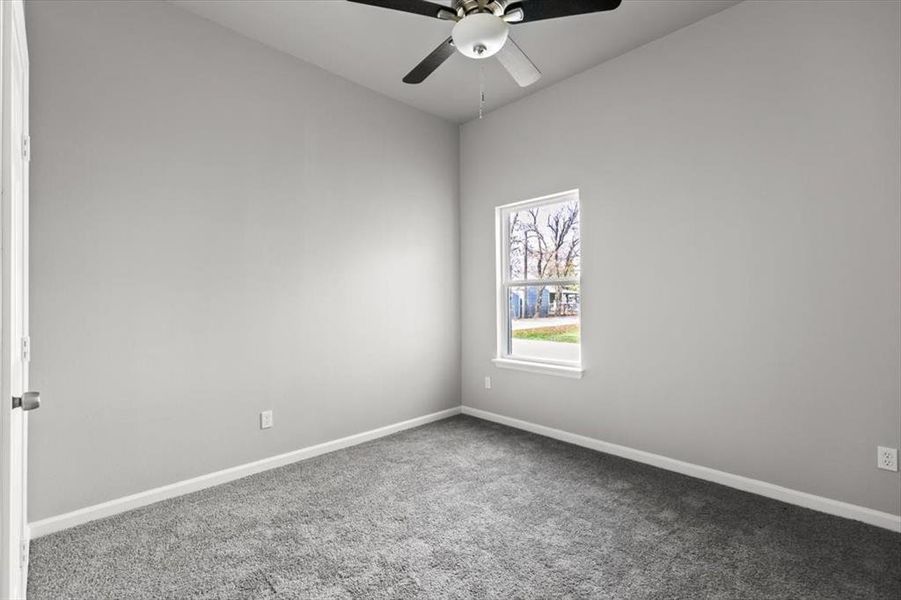 Carpeted bedroom featuring ceiling fan