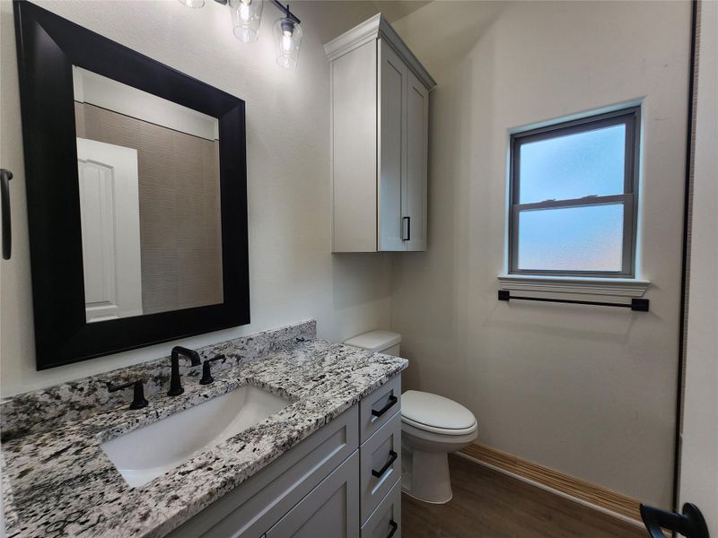 Bathroom vanity featuring a rectangular undermount sink, granite countertop, and matte black faucet