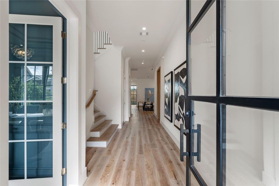 High ceilings and hardwoods welcome guests to true luxury in the generous entry. The glass door floods the space with sunlight for a welcoming atmosphere. A sleek staircase is complete with oak treads and railing.