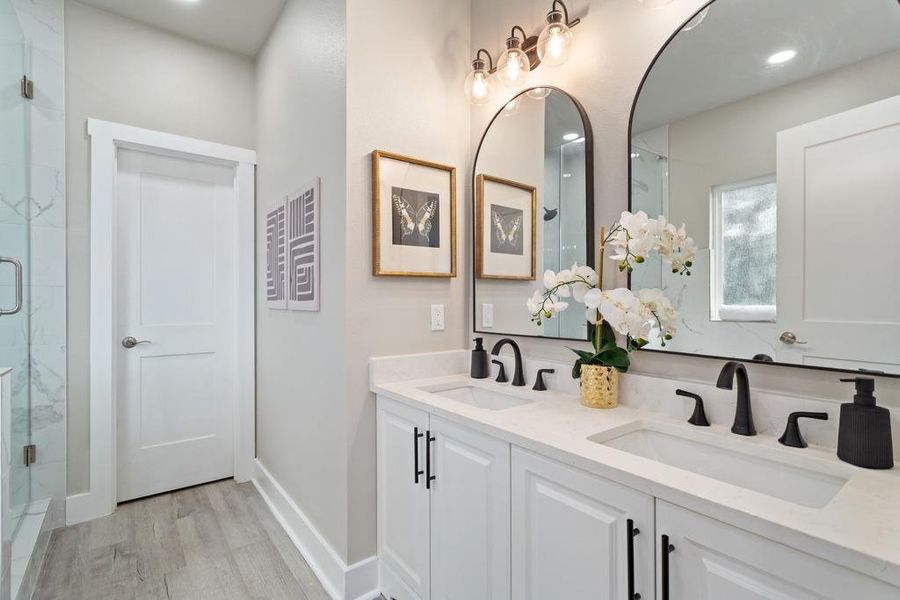 Dual vanity with sleek black fixtures and arch-top mirrors complement this well-appointed bathroom. Dual vanity with sleek black fixtures and arch-top mirrors complement this well-appointed bathroom.