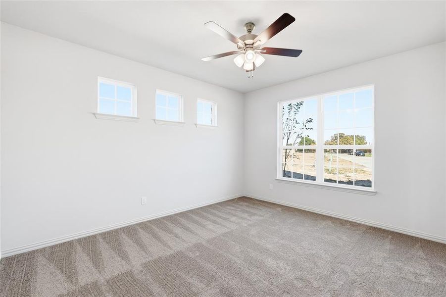 Empty room featuring light carpet and a ceiling fan