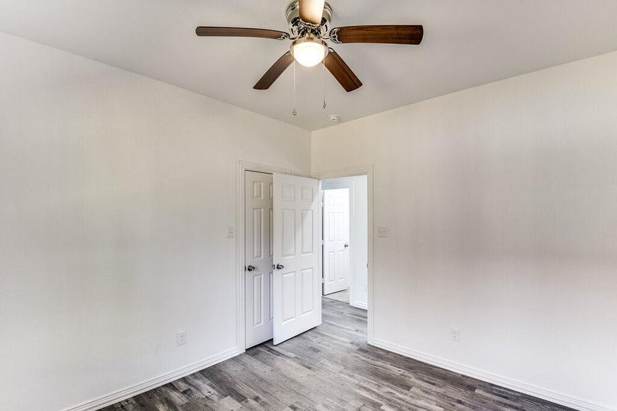 Empty room with light hardwood / wood-style floors and ceiling fan