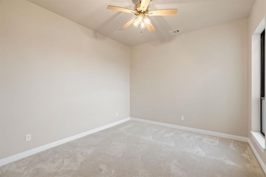 Empty room featuring light carpet and ceiling fan