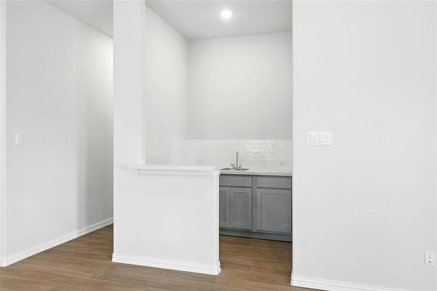 Bar area featuring gray cabinets, wood finished floors, tasteful backsplash, and recessed lighting Bar area featuring gray cabinets, wood finished floors, tasteful backsplash, and recessed lighting