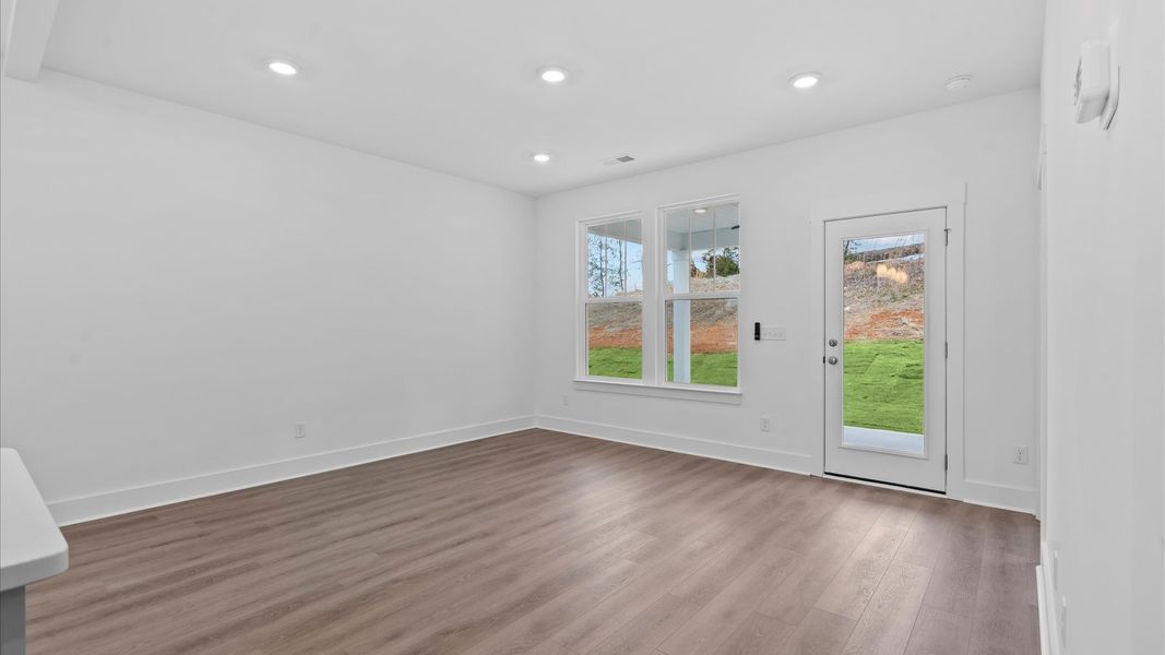 Spacious family room with rich hardwood flooring and elegant trim work in a reputable DRB Homes build