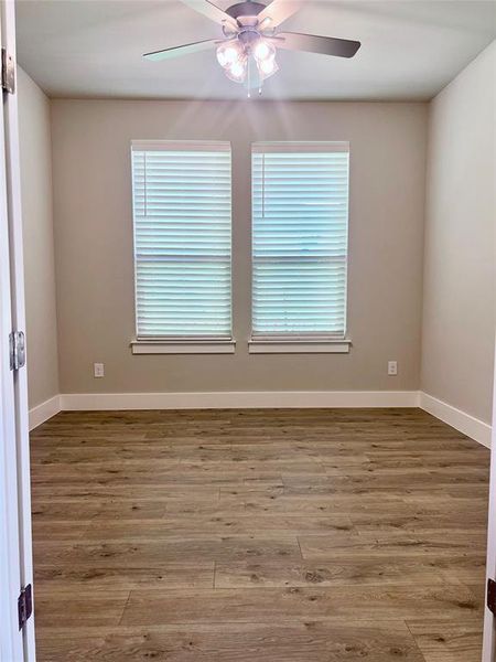 Office with hardwood / wood-style floors, ceiling fan, and a wealth of natural light.