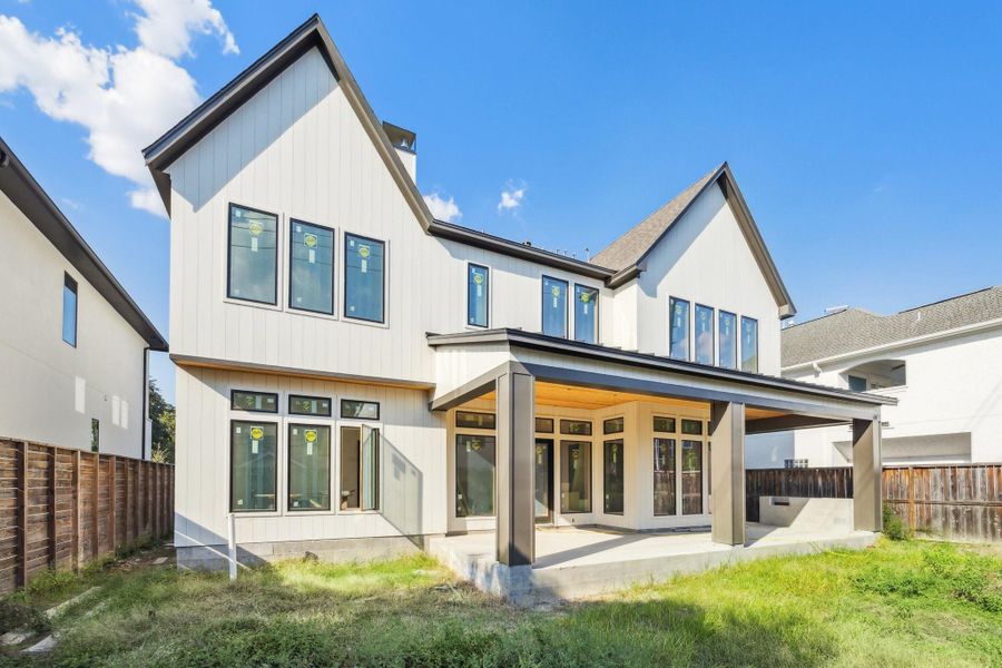 Back elevation of the home with a covered patio.  Partial view of the back yard with plenty of room for a pool.