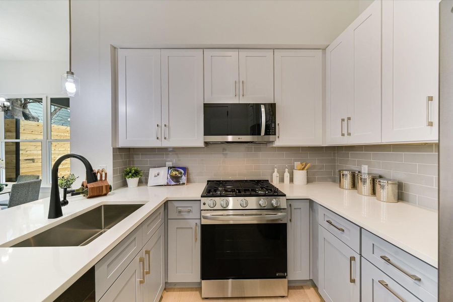 The designer pendant lighting and stainless steel appliances ensure this kitchen is as functional as it is photogenic.