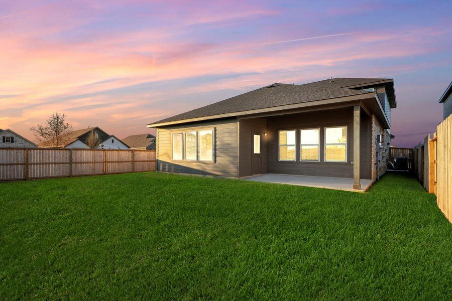 Another twilight view showcases the spacious backyard and extended covered patio, ideal for relaxing evenings or entertaining under the stars. The large windows across the back of the home reflect the serene beauty of sunset skies. Another twilight view showcases the spacious backyard and extended covered patio, ideal for relaxing evenings or entertaining under the stars. The large windows across the back of the home reflect the serene beauty of sunset skies.