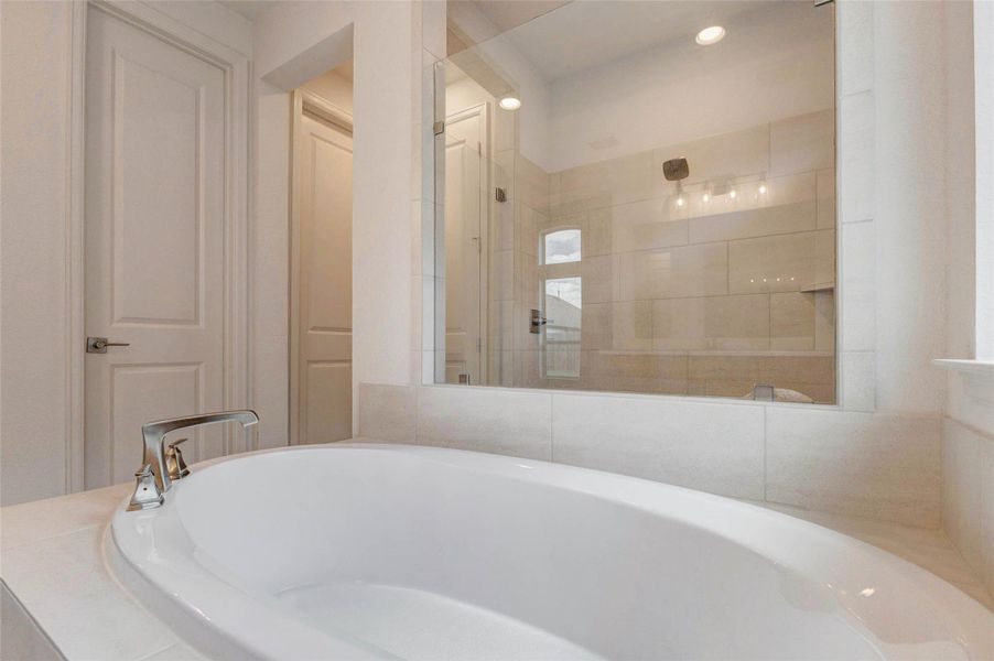 This photo showcases a modern bathroom featuring a sleek, freestanding bathtub with a chrome faucet. The space is accented by a large, glass-enclosed shower and elegant lighting, creating a spa-like ambiance. This photo showcases a modern bathroom featuring a sleek, freestanding bathtub with a chrome faucet. The space is accented by a large, glass-enclosed shower and elegant lighting, creating a spa-like ambiance.