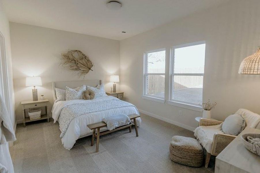 Bedroom featuring light carpet and baseboards Bedroom featuring light carpet and baseboards