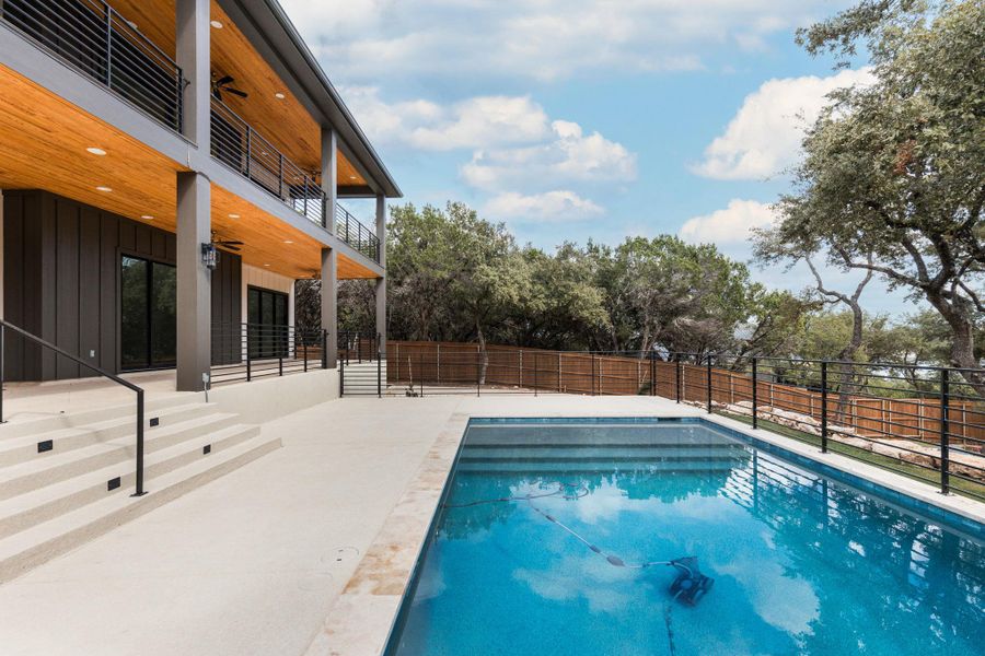 View of pool with a patio, a balcony, ceiling fan, and a fenced backyard