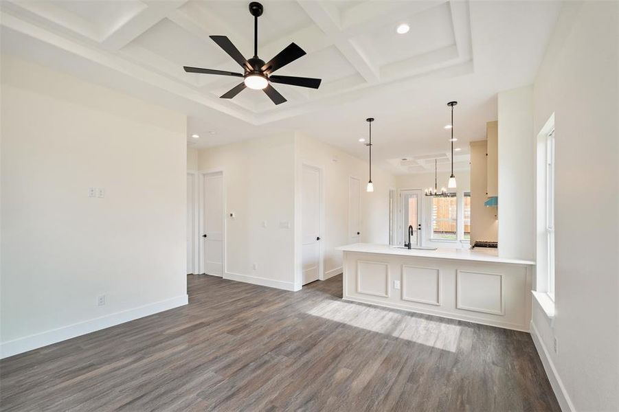 Unfurnished living room with coffered ceiling, a chandelier, recessed lighting, dark wood-style floors, and beam ceiling Unfurnished living room with coffered ceiling, a chandelier, recessed lighting, dark wood-style floors, and beam ceiling