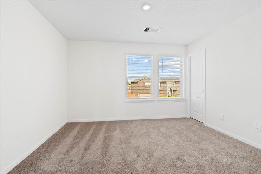 This secondary bedroom offers comfort and style with plush carpeting, neutral paint tones, recessed lighting, large windows with blinds, and a walk-in closet. This secondary bedroom offers comfort and style with plush carpeting, neutral paint tones, recessed lighting, large windows with blinds, and a walk-in closet.