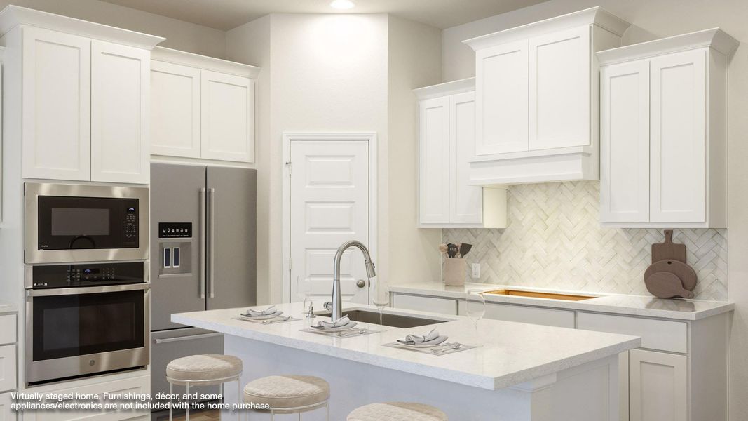 Kitchen featuring decorative backsplash, a breakfast bar area, appliances with stainless steel finishes, a sink, and white cabinetry