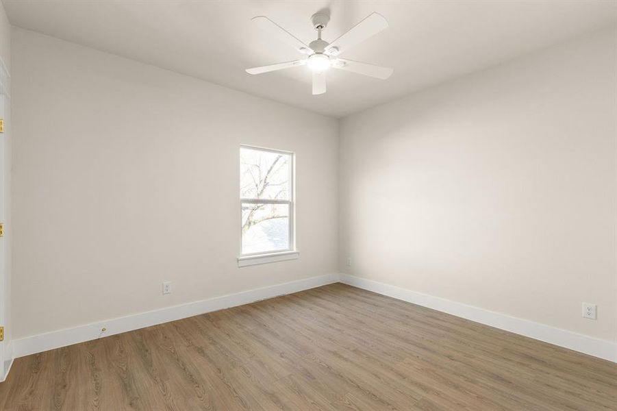 Unfurnished room featuring a ceiling fan, baseboards, and wood finished floors