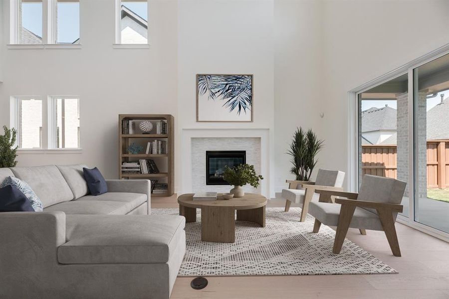Living room featuring a high ceiling, wood finished floors, and a glass covered fireplace