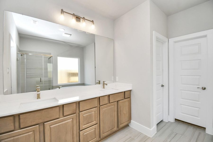 Escape to a spa-like oasis in this primary bathroom. Enjoy a walk-in shower with tile surround, a separate garden tub with custom detailing, and an elegant vanity featuring light countertops, modern hardware, and beautiful vanity and recessed lights. Experience luxury and relaxation in every detail. Escape to a spa-like oasis in this primary bathroom. Enjoy a walk-in shower with tile surround, a separate garden tub with custom detailing, and an elegant vanity featuring light countertops, modern hardware, and beautiful vanity and recessed lights. Experience luxury and relaxation in every detail.
