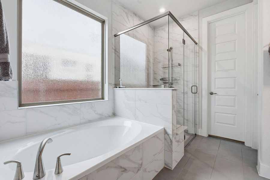 Bathroom featuring a marble finish shower, a bath, and tile patterned flooring