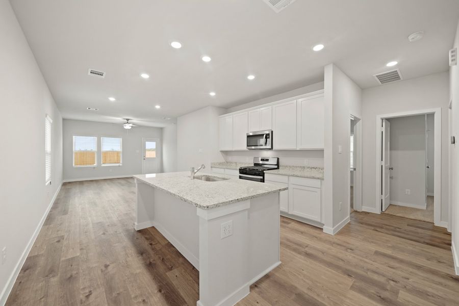 A kitchen with white cabinets.