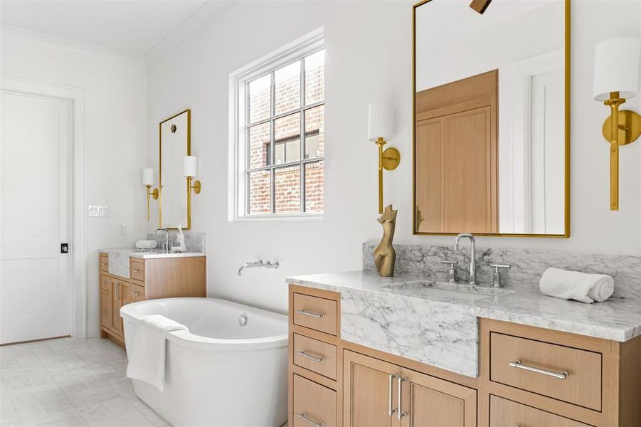 Full bath featuring a freestanding tub, two vanities, and crown molding Full bath featuring a freestanding tub, two vanities, and crown molding