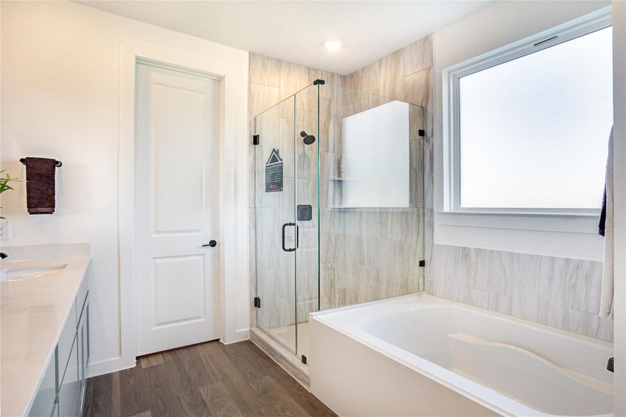 This modern bathroom features a sleek glass-enclosed shower, a spacious bathtub, and elegant wood flooring. A large frosted window provides natural light, while a double vanity offers ample counter space. This modern bathroom features a sleek glass-enclosed shower, a spacious bathtub, and elegant wood flooring. A large frosted window provides natural light, while a double vanity offers ample counter space.