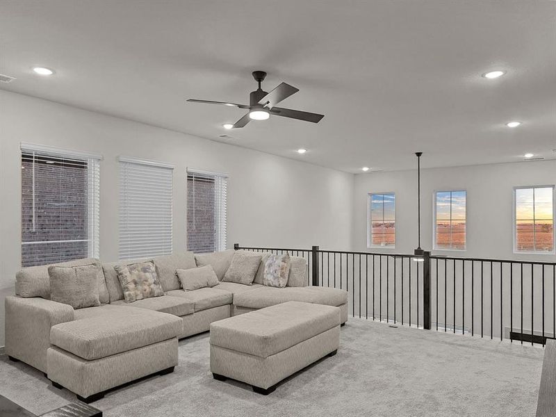 Carpeted living room with ceiling fan