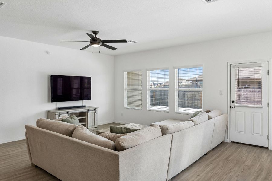 A welcoming living area with rich LVP flooring and abundant natural illumination.