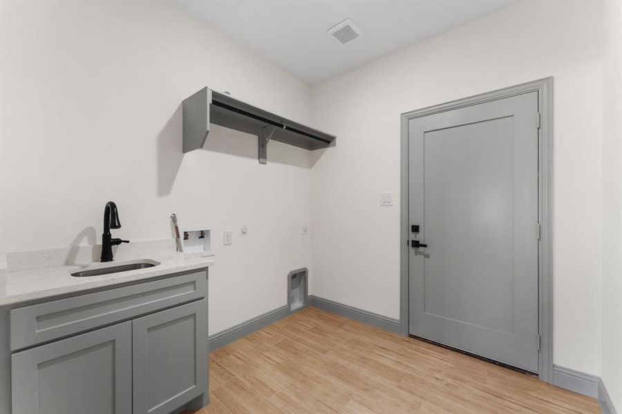 Washroom featuring light wood-type flooring, hookup for a gas dryer, and washer hookup