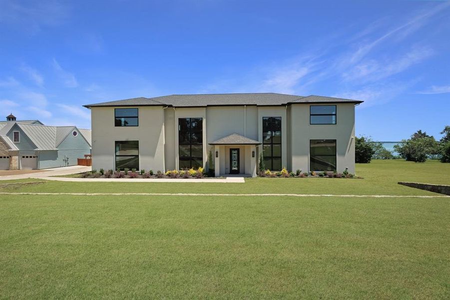 Contemporary two-story residence featuring a stucco exterior and prominent large-scale windows