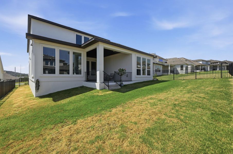 Clean lines and a covered rear porch define the back of this modern stucco home.