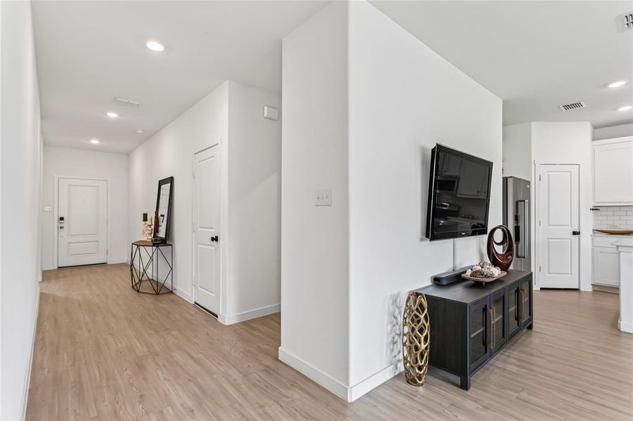 The interior of the property features light-colored flooring and white walls throughout, with recessed lighting visible in the ceiling
