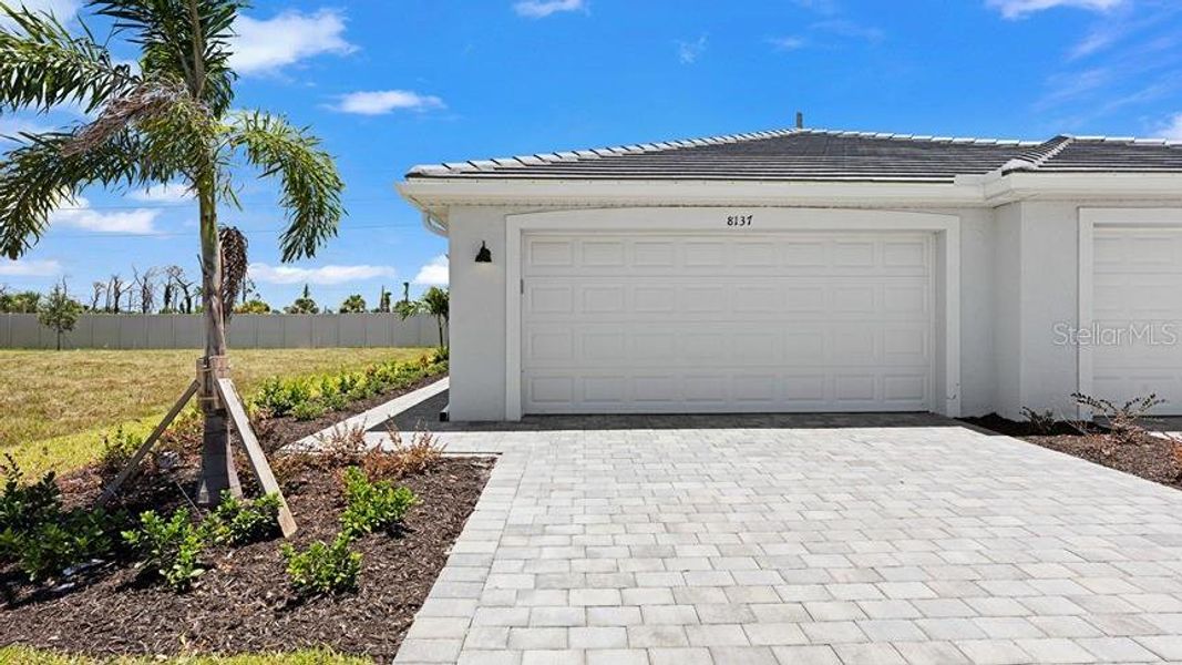 Front exterior of a new home in Palm Lake at Coco Bay, Englewood, FL, highlighting curb appeal (Image 2).