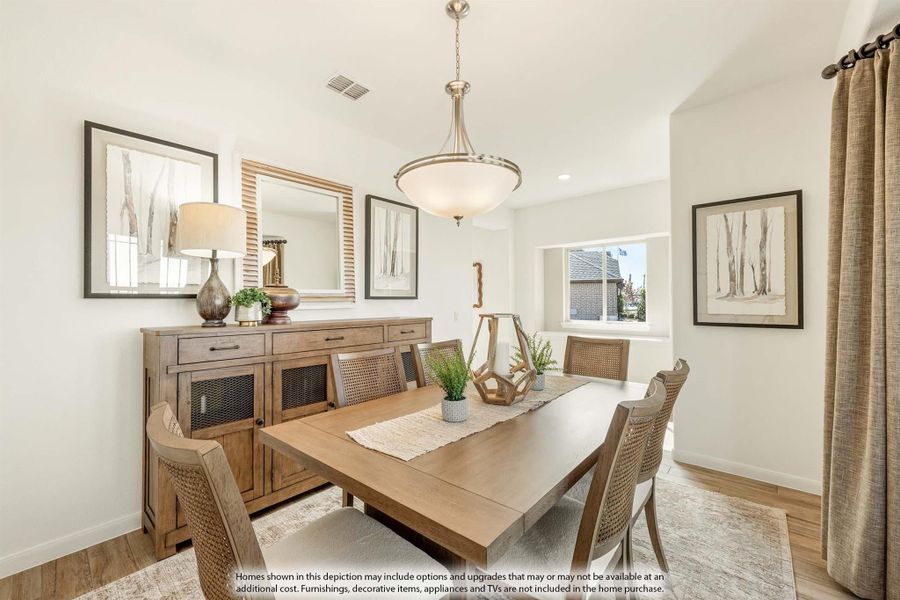 Dining room with wood table, woven chairs, buffet sideboard, and pendant light fixture