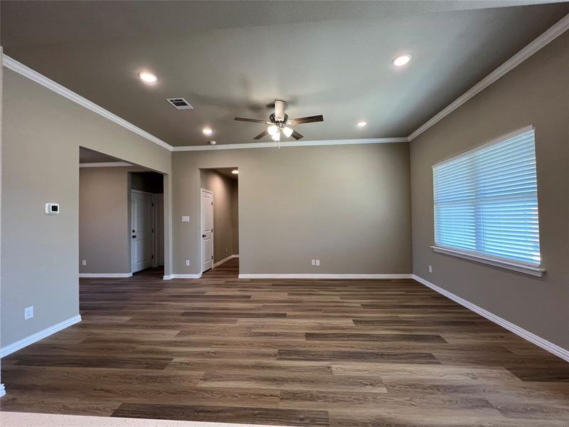 Unfurnished room featuring ceiling fan, dark wood-type flooring, and crown molding