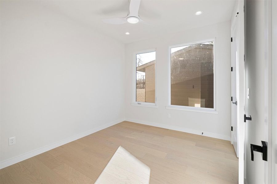 Spare room featuring light wood-type flooring, a ceiling fan, and recessed lighting