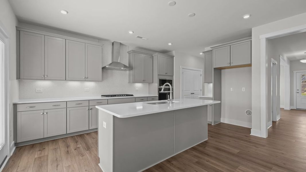 Burton Design gourmet kitchen with wall oven and microwave, vented hood, & cooktop. Lakeside Glen by DRB Homes in York, SC. Burton Design gourmet kitchen with wall oven and microwave, vented hood, & cooktop. Lakeside Glen by DRB Homes in York, SC.