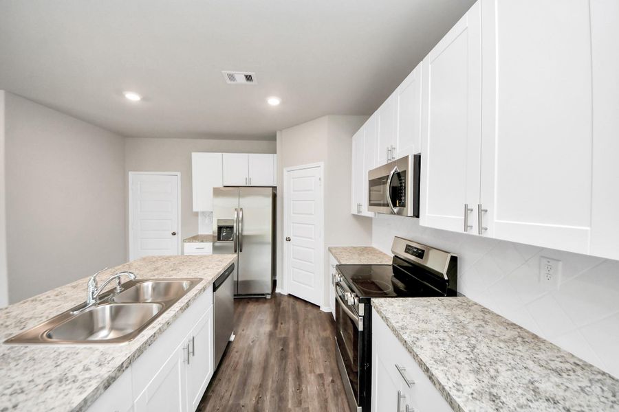 White kitchen with handles and brand new stainless steel appliances White kitchen with handles and brand new stainless steel appliances