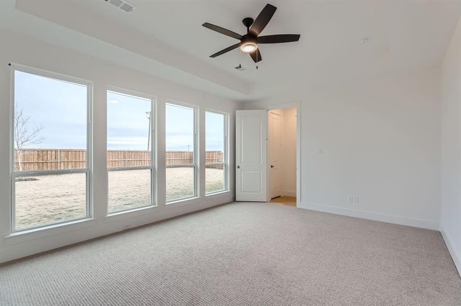 Carpeted empty room featuring ceiling fan