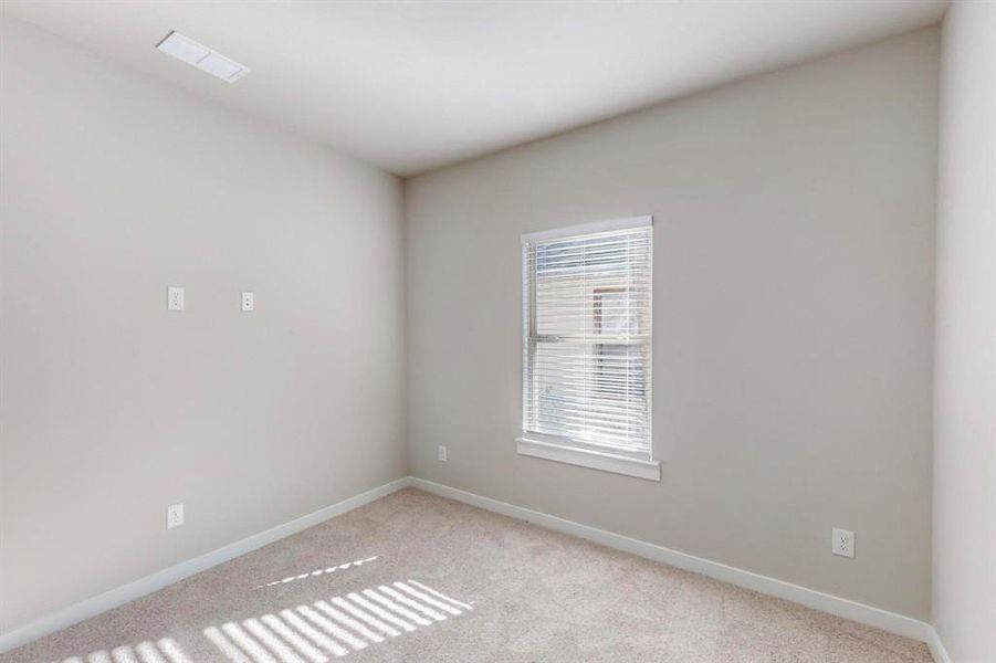 Empty room featuring light colored carpet