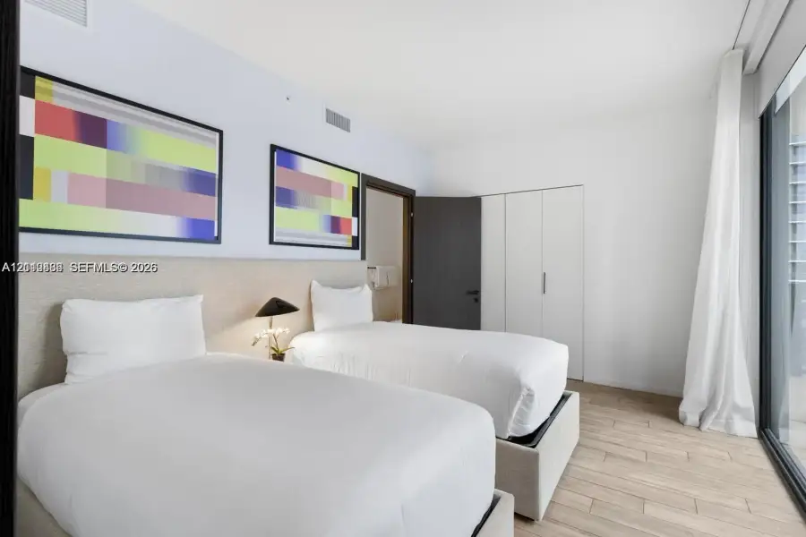 Wood-finish flooring, full-height built-in storage cabinetry, and floor-to-ceiling glass paneling Wood-finish flooring, full-height built-in storage cabinetry, and floor-to-ceiling glass paneling