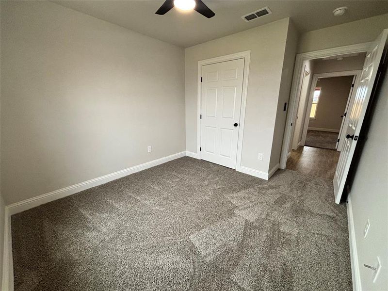 Unfurnished bedroom with carpet floors and ceiling fan