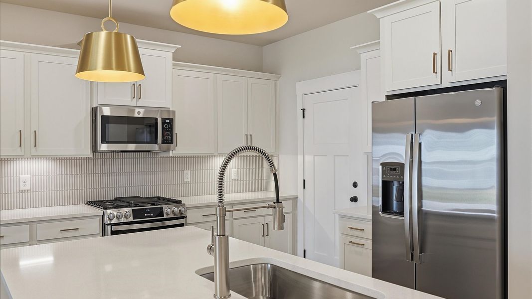 Well-designed kitchen with a center island and tasteful finishes that elevate everyday living by DRB Homes Well-designed kitchen with a center island and tasteful finishes that elevate everyday living by DRB Homes
