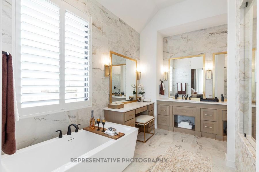 Full bath with a freestanding bath, marble finish floors, lofted ceiling, vanity, and a shower Full bath with a freestanding bath, marble finish floors, lofted ceiling, vanity, and a shower