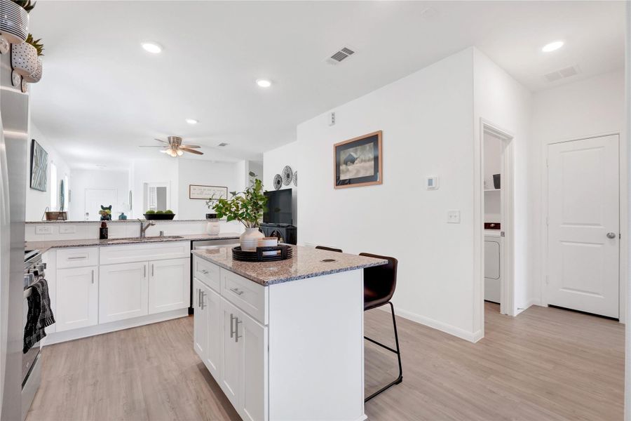 Fall in love with a modern chef’s kitchen featuring stainless-steel appliances, sleek cabinetry, ample counter space, and a large breakfast bar, creating a perfect balance of beauty and functionality.