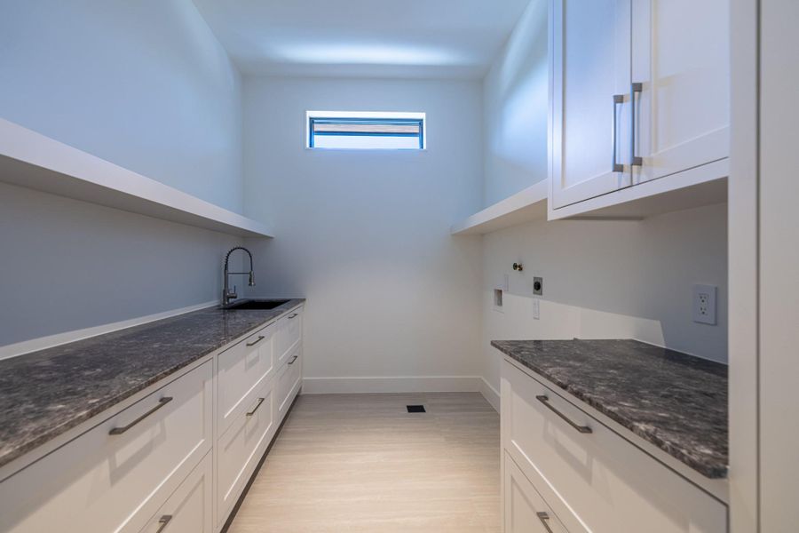 Laundry room with storage cabinetry. Laundry room with storage cabinetry.